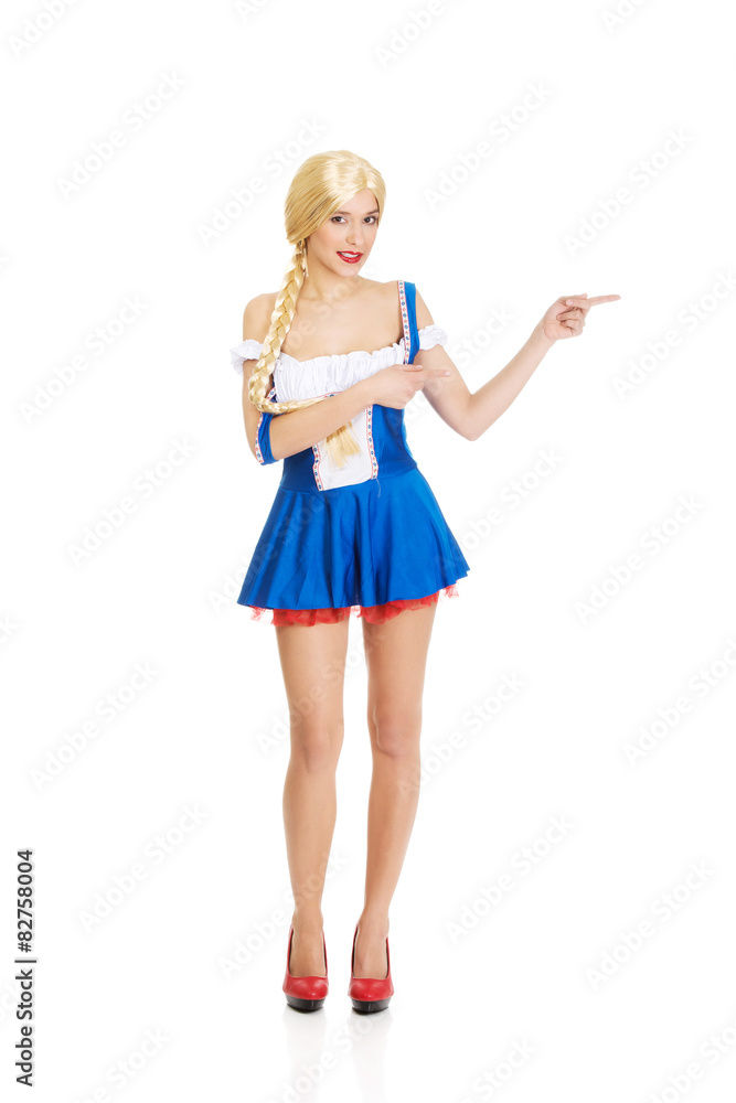 Fototapeta premium Woman in Bavarian dress pointing aside.