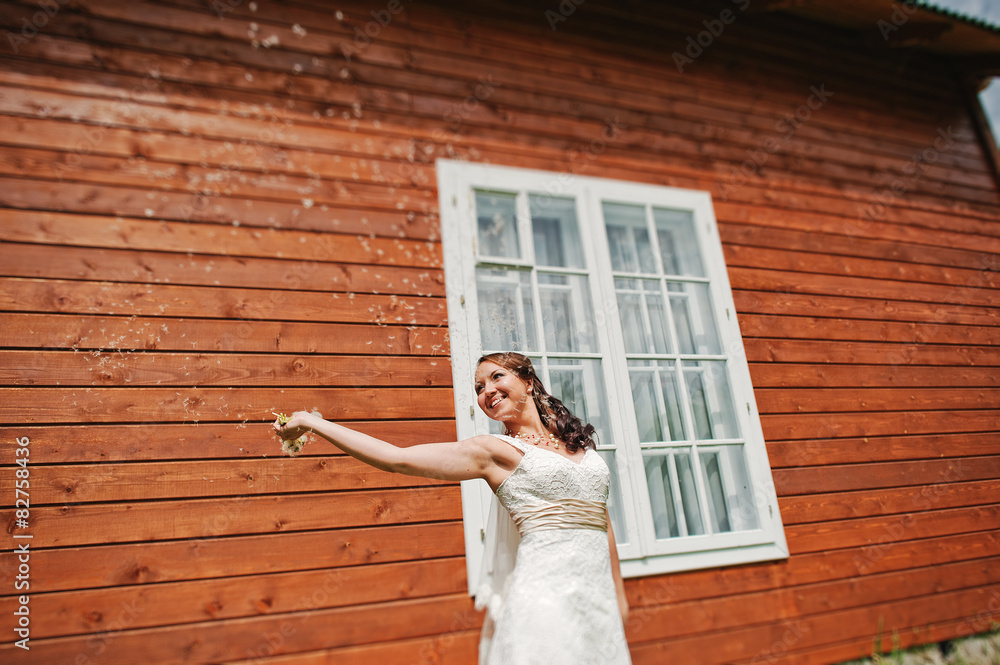 Bride with dandelion near window at the wooden house Bride with dandelion near window at the wooden house