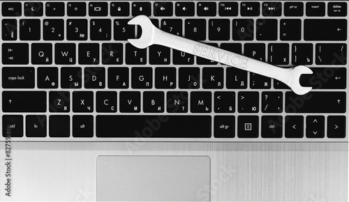 electronic technical support concept - spanners on computer