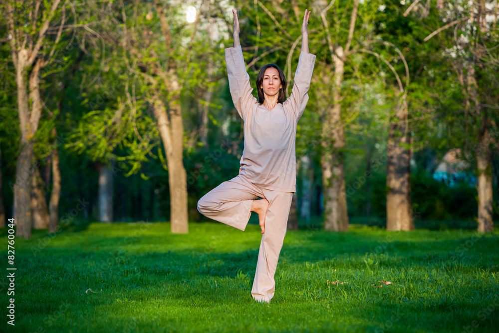 Practicing yoga in the morning, with trees  background