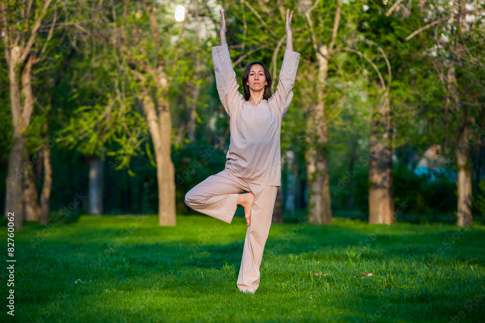 Practicing yoga in the morning, with trees background Practicing yoga in the morning, with trees background