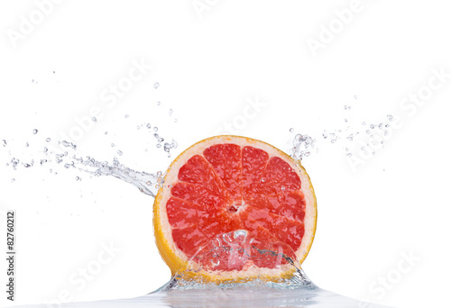 Fresh grapefruit in water splash on white
