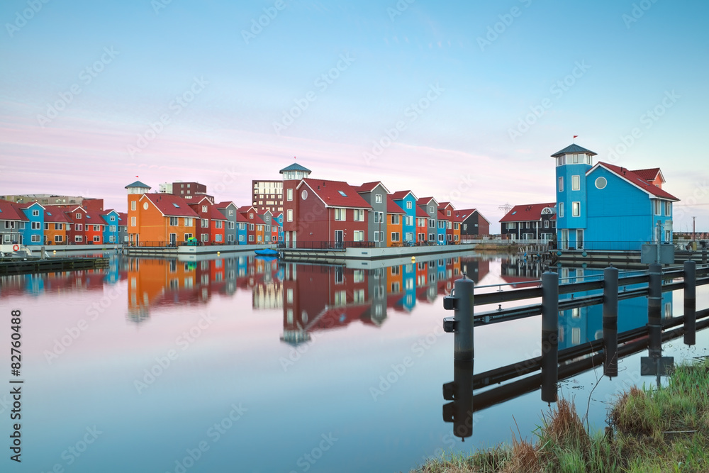 Obraz premium colorful buildings on water at sunrise