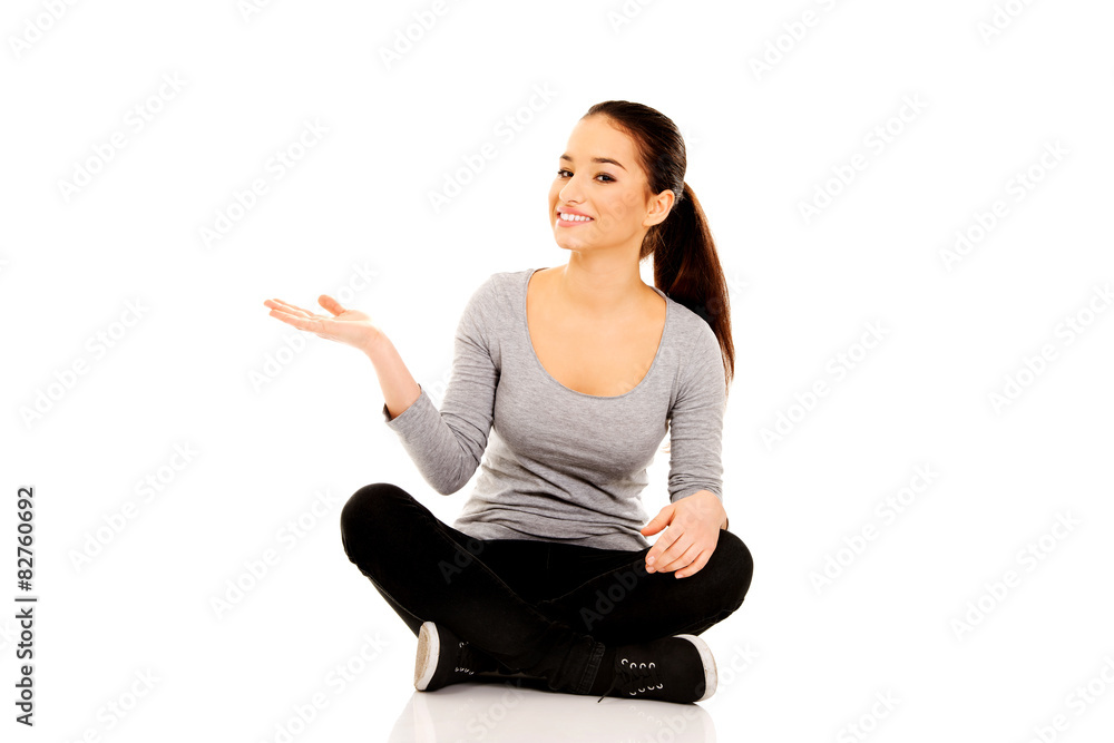 Woman sitting cross legged with open hand. Woman sitting cross legged with open hand.