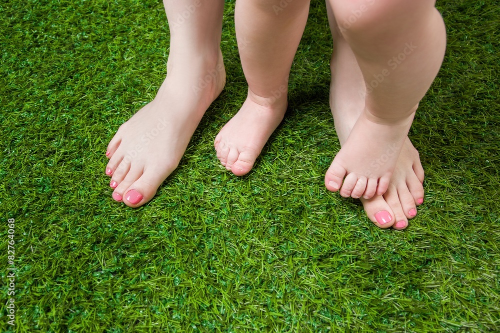 Mother and baby legs standing  on green grass