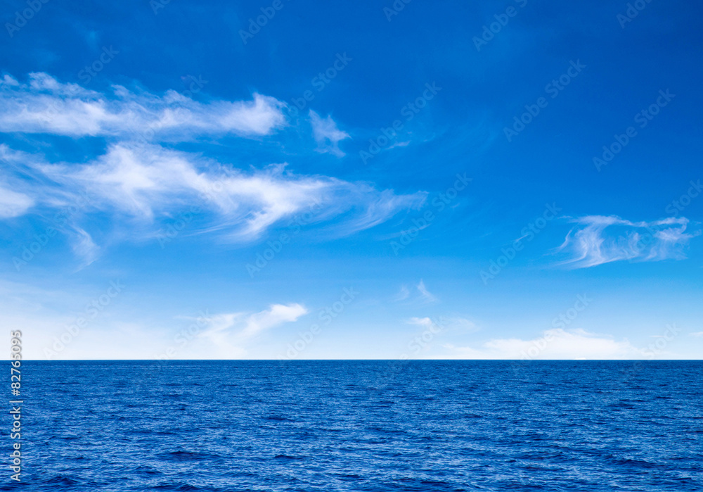 Obraz premium białe puszyste chmury z tęczą na niebieskim niebie