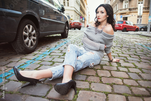 Young woman sitting on the city street