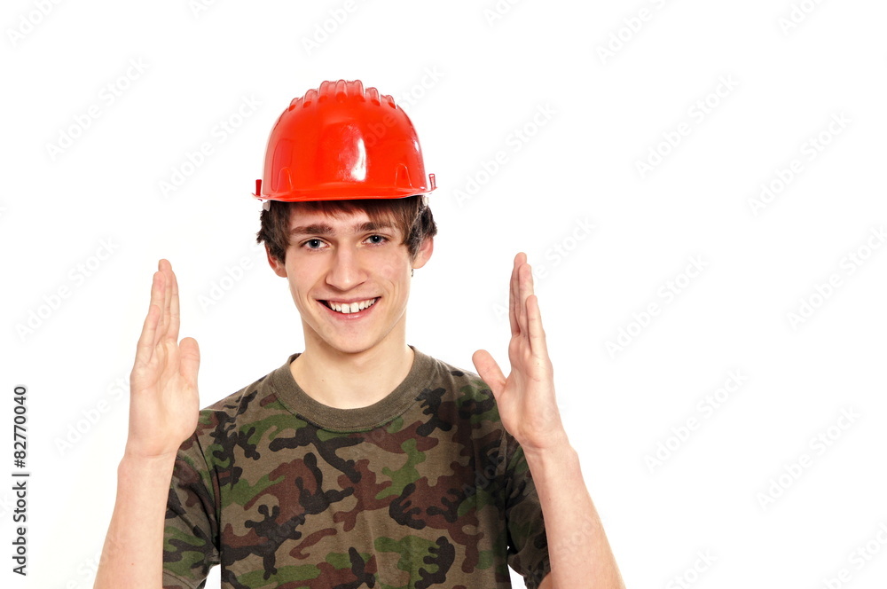 Smiling young man in protective helmet shows size Smiling young man in protective helmet shows size