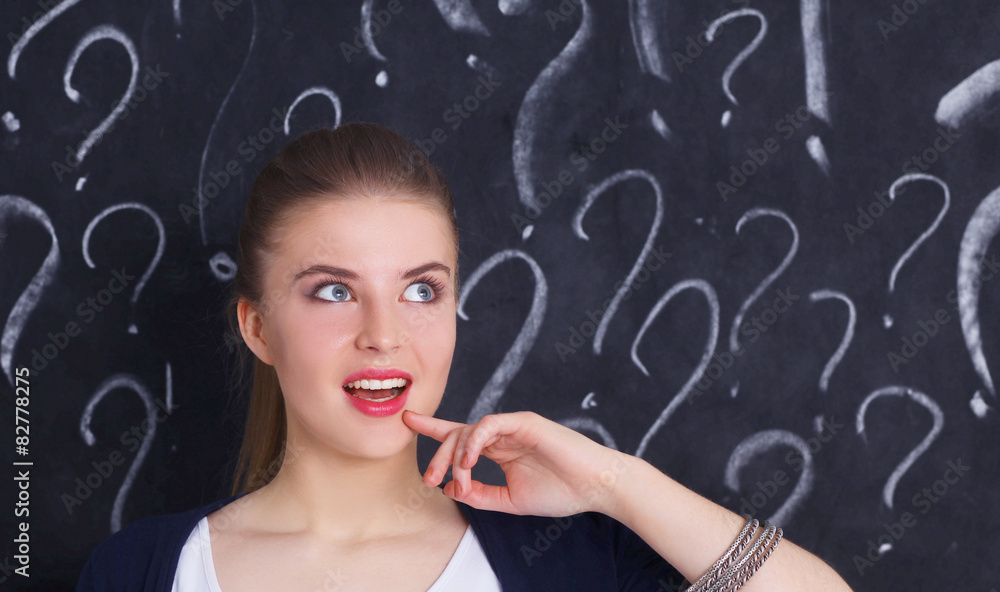 Young girl with question mark on a gray background Young girl with question mark on a gray background