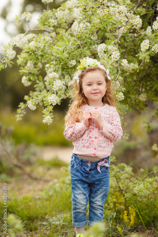 Portrait of little girl outdoors in a lush garden. Portrait of little girl outdoors in a lush garden.