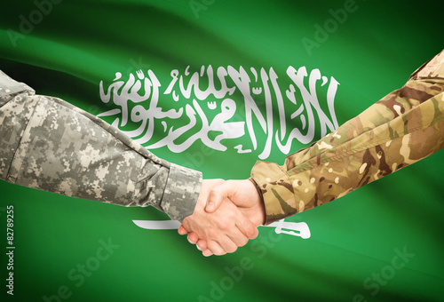 Obraz na płótnie Men in uniform shaking hands with flag - Saudi Arabia w salonie