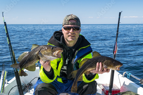 Angler with cod trophy fishes
