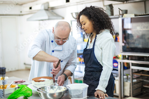 young girl learns to bake cakes with porfessionalnym baker