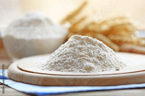Pile of flour on wooden cutting board and blurred background