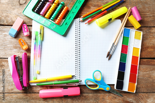 Notebook and bright school stationery on old wooden table