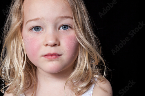 Close up portrait of a young girl on black background.
