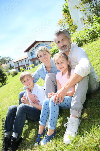 Happy family sitting in home private garden