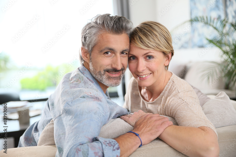 Middle-aged couple relaxing in sofa at home Middle-aged couple relaxing in sofa at home