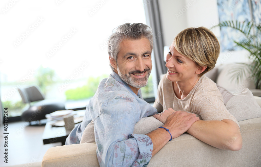 Middle-aged couple relaxing in sofa at home Middle-aged couple relaxing in sofa at home