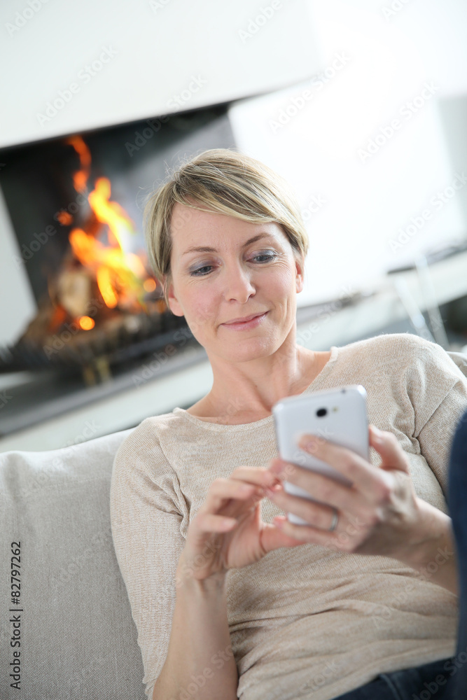Middle-aged woman sending message with smartphone