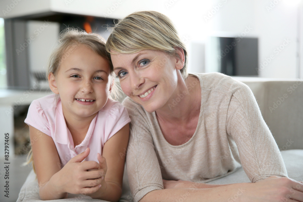 Portrait of mother and daughter laying in couch at home Portrait of mother and daughter laying in couch at home