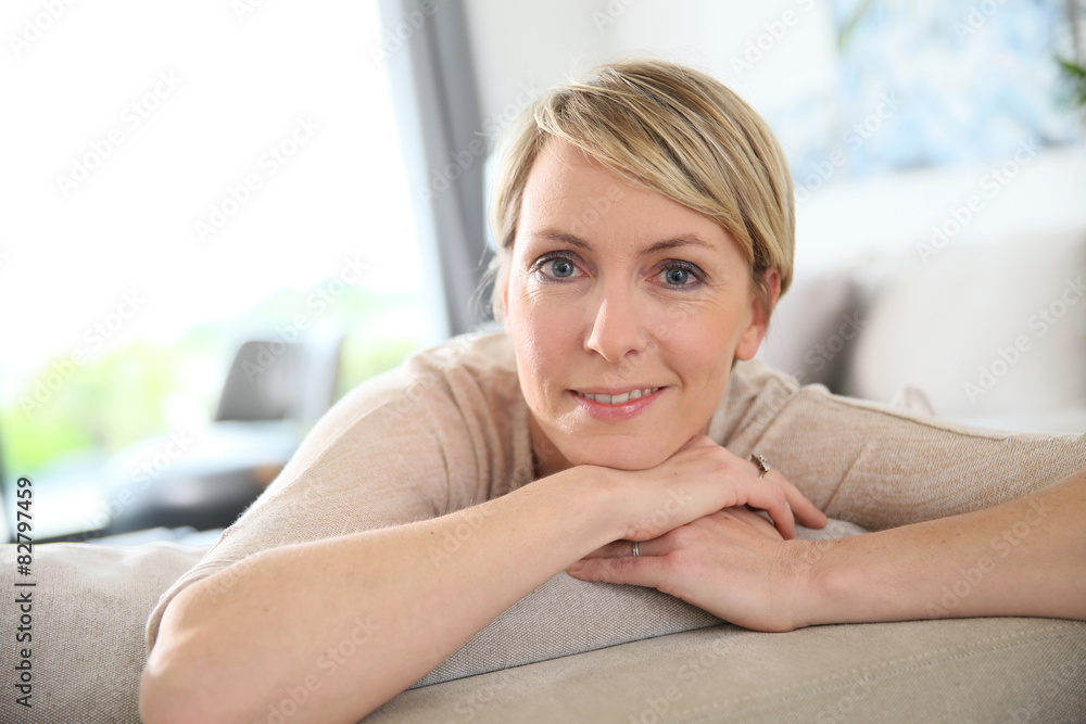 Middle-aged woman relaxing in sofa at home Middle-aged woman relaxing in sofa at home