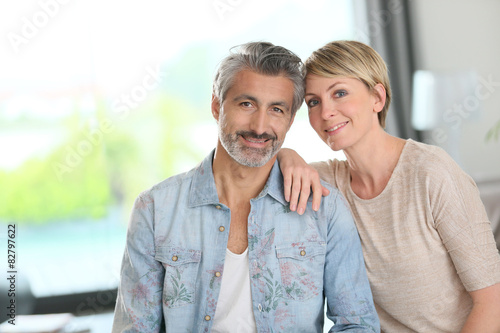 Smiling mature couple standing in contemporary home