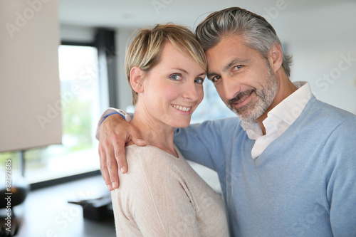 Smiling middle-aged couple standing in brand new home
