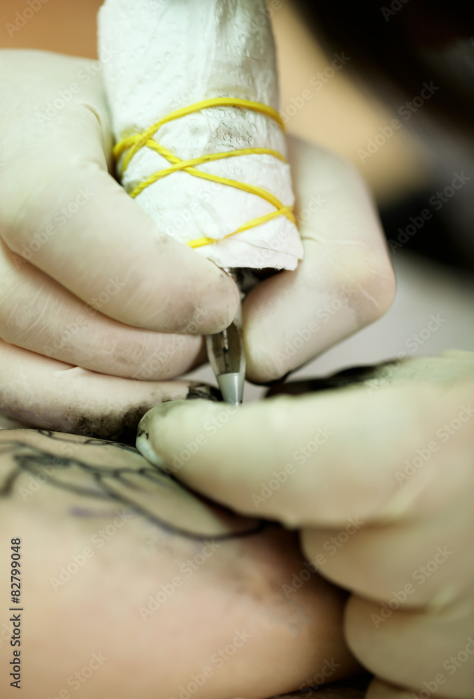 Tattoo artist at work, close-up Tattoo artist at work, close-up
