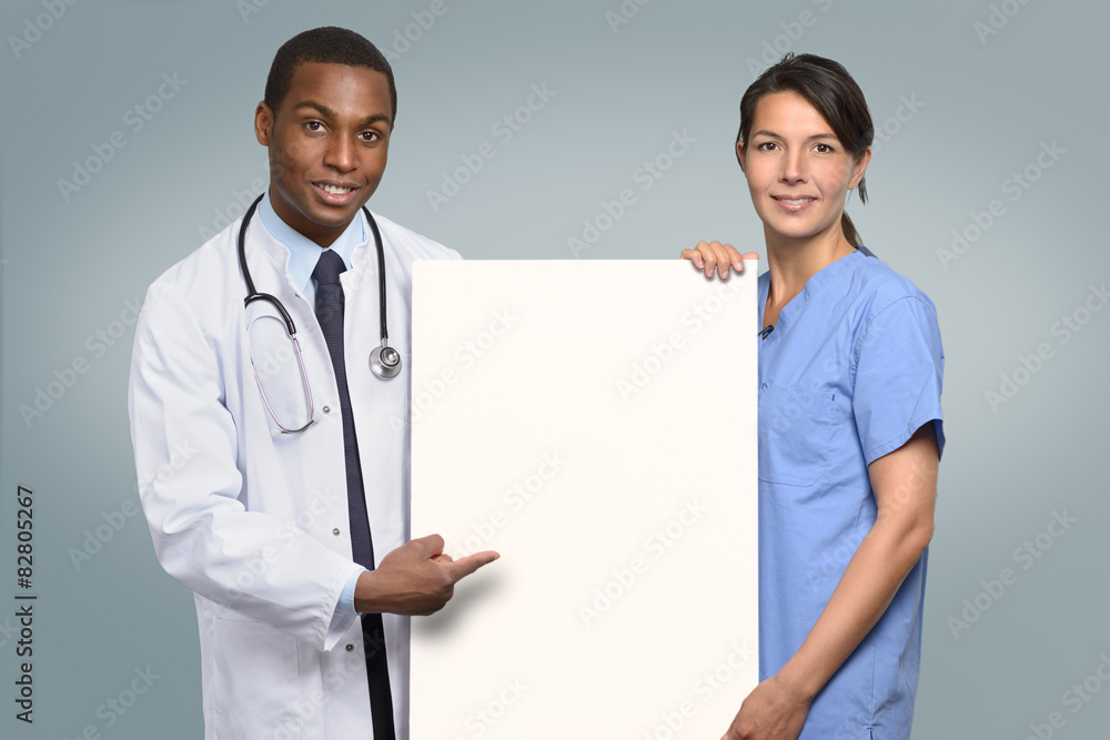 Multi-Ethnisches Mediziner Team hält ein weißes Plakat Multi-Ethnisches Mediziner Team hält ein weißes Plakat
