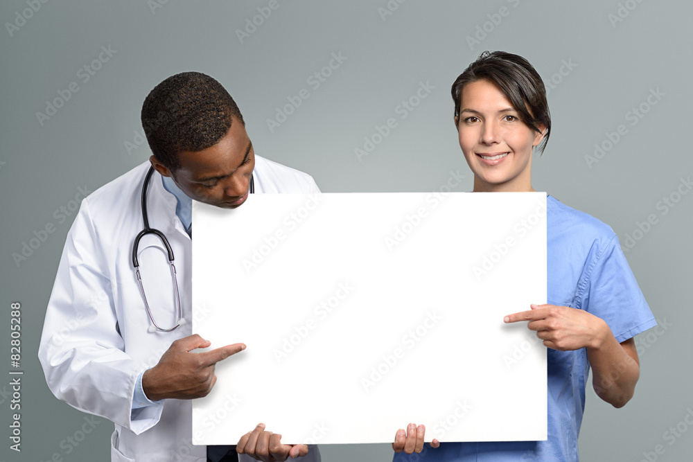 Multi-Ethnisches Mediziner Team hält ein weißes Plakat Multi-Ethnisches Mediziner Team hält ein weißes Plakat