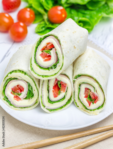 Tortilla roll with soft cheese, chicken ham, and vegetables
