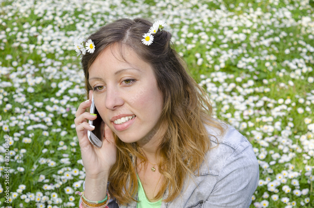 Brunette talking on her phone among the daisies Brunette talking on her phone among the daisies