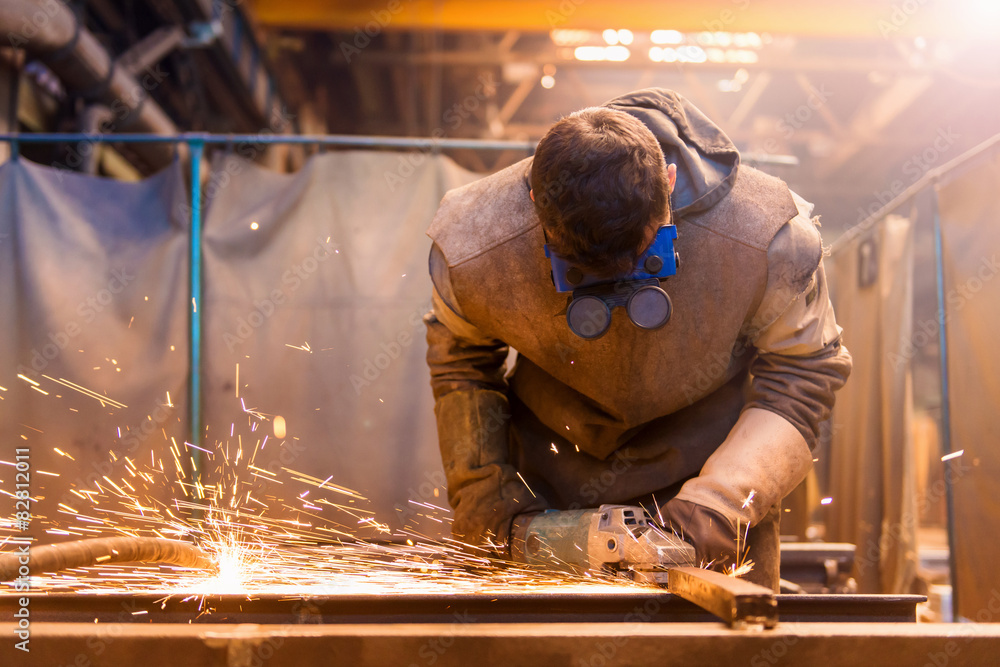 Young man with protective mask welding in a factory Young man with protective mask welding in a factory