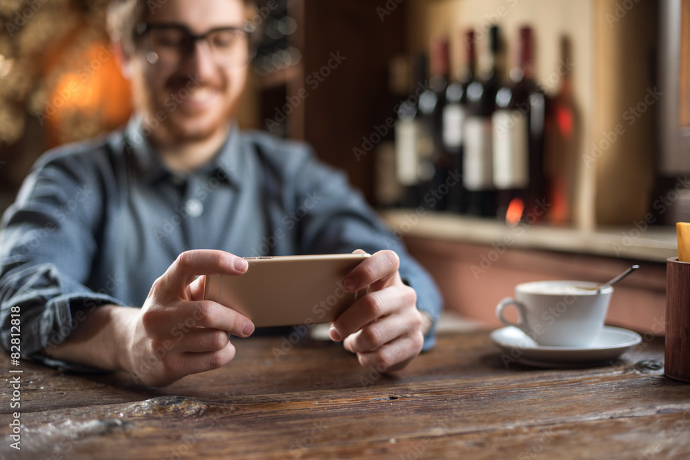 Hipster guy at the restaurant using a mobile phone Hipster guy at the restaurant using a mobile phone