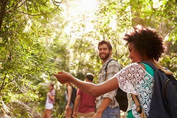 Woman Examining Leaves On Plant During Countryside Walk