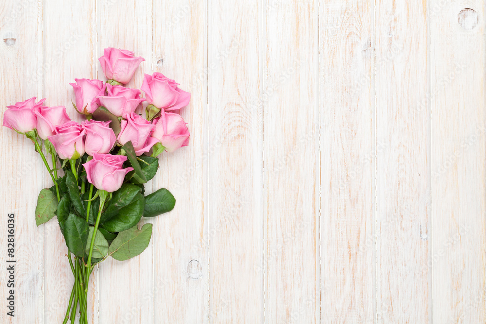 Pink roses bouquet over wooden table