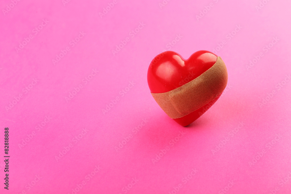 Fototapeta premium Heart with plaster on colorful background