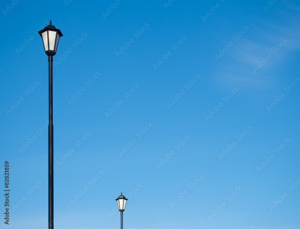 Street lamps silhouette against the blue sky