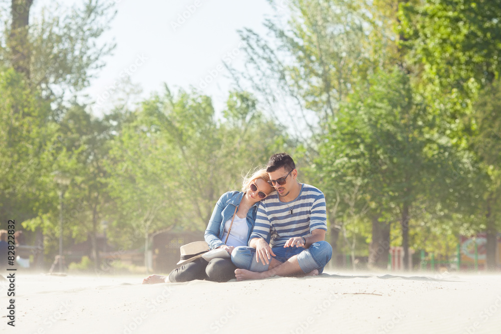 Fototapeta premium Romantic young couple sitting on the beach