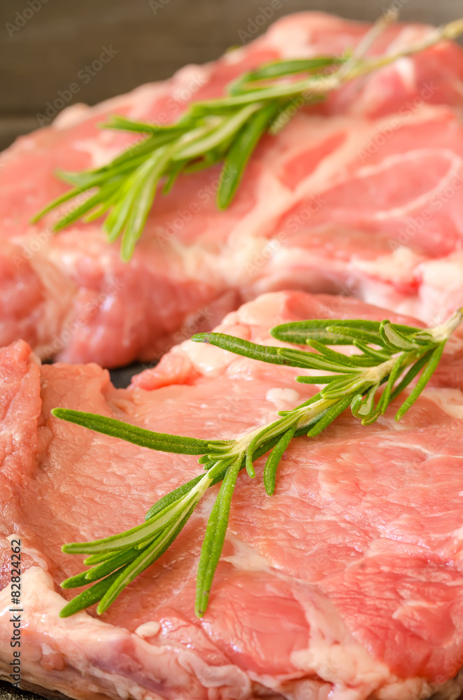 Raw steak with rosemary on cast-iron frying pan Raw steak with rosemary on cast-iron frying pan