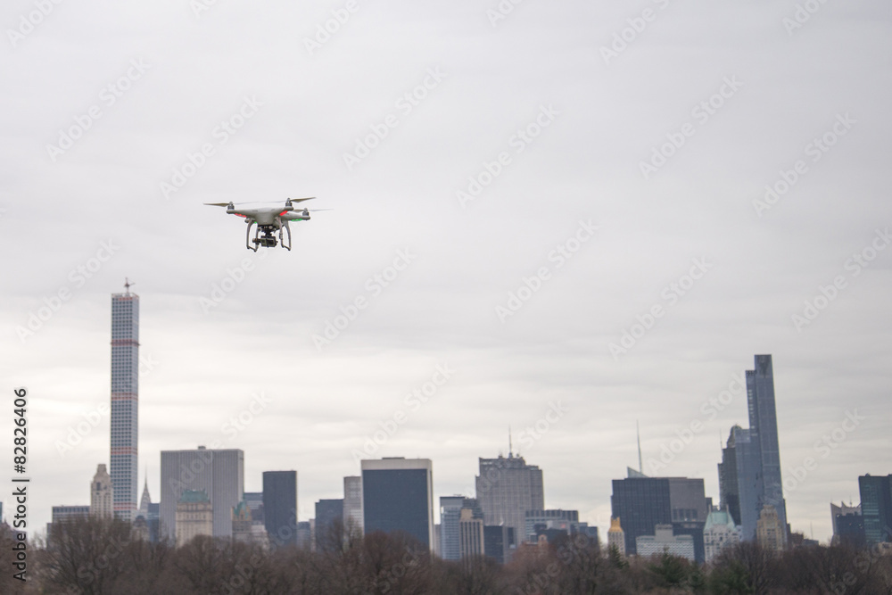 White drone flying in Central Park on a cloudy day White drone flying in Central Park on a cloudy day