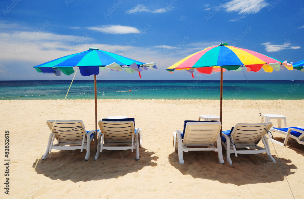 Summer paradise with white chair and colorful umbrella at Phuket beach, Thailand