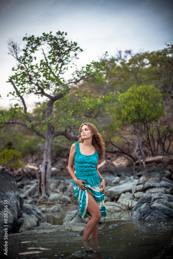 Young beautiful romantic woman in  long turquoise dress standing