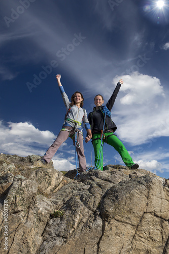 Group of two happy female climbers celebrates victory