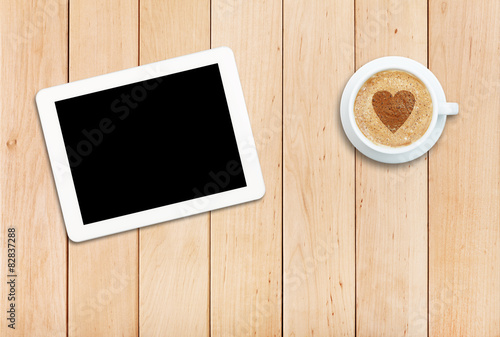 Tablet and coffee on a wooden table