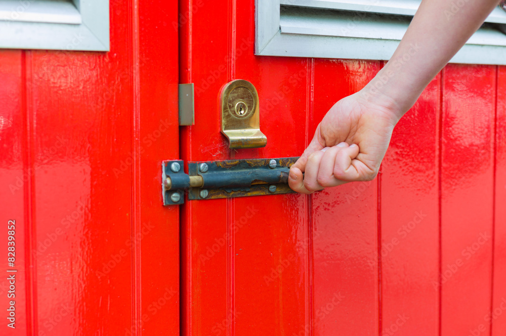 Hand opening little red door Hand opening little red door