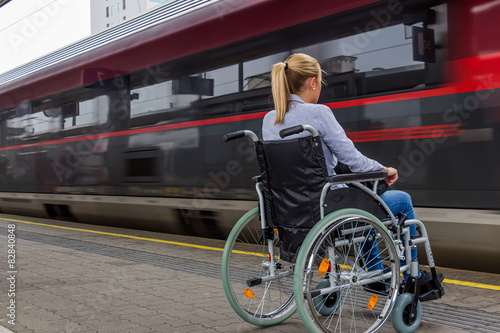 Fototapeta Naklejka Na Ścianę i Meble -  Frau sitzt in einem Rollstuhl auf einem Bahnhof