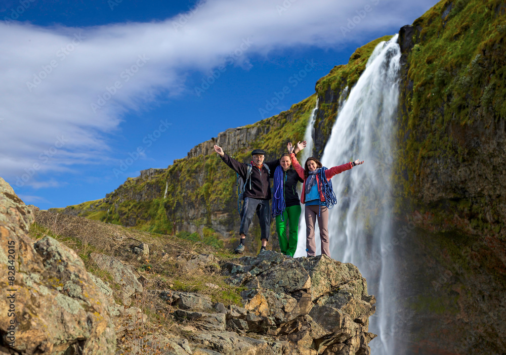 Group of climbers on waterfall background