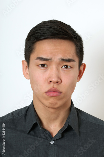 Strict young Asian man looking at camera